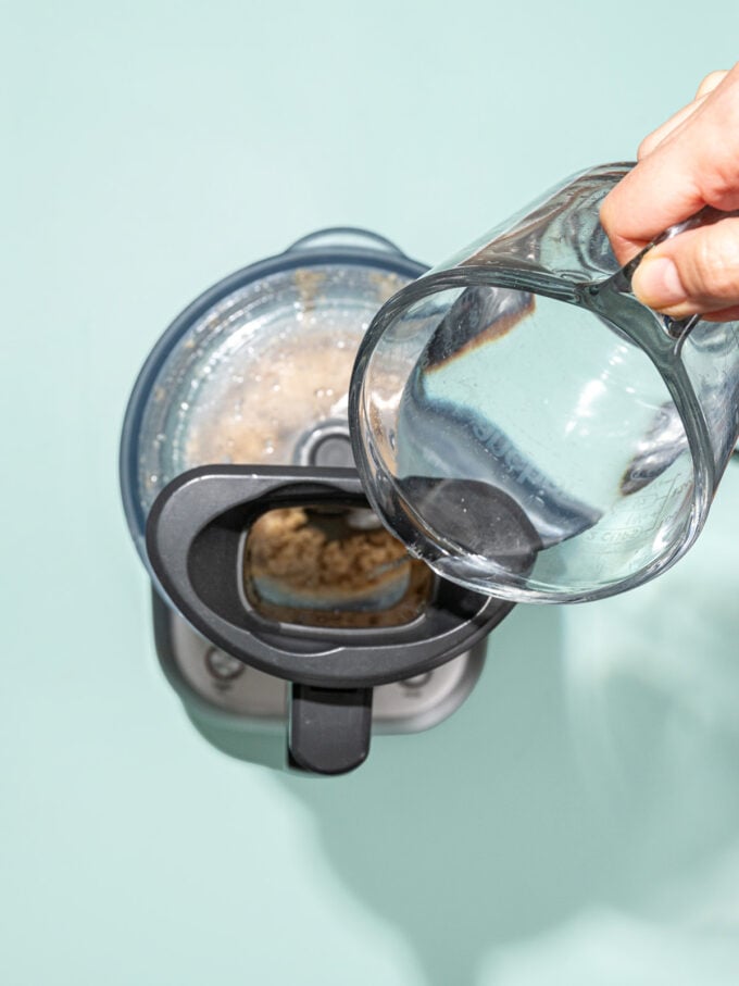 pouring water into food processor spout