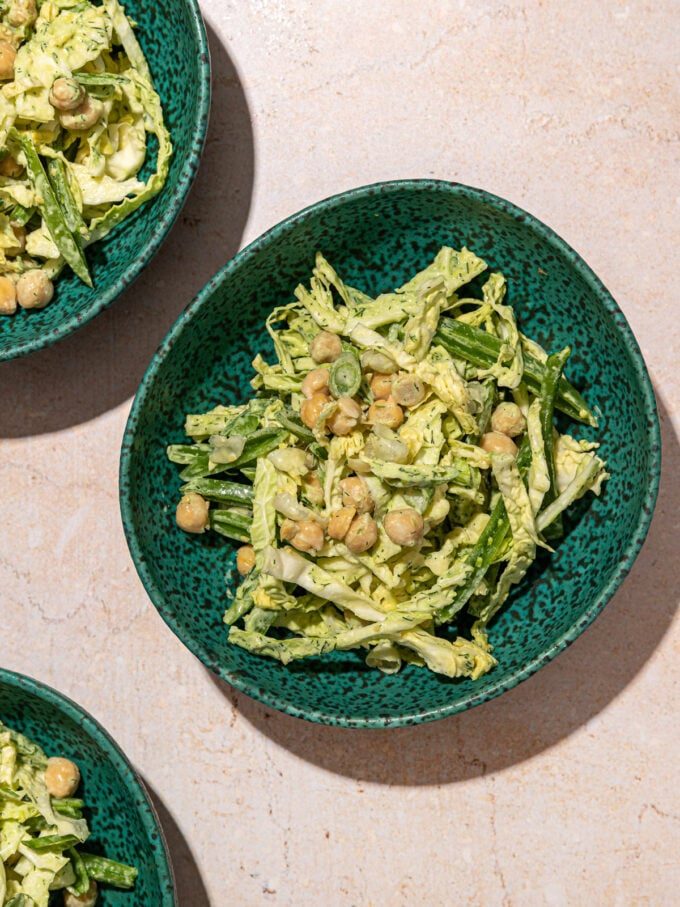 green goddess shredded cabbage and chickpea salad in 3 blue bowls