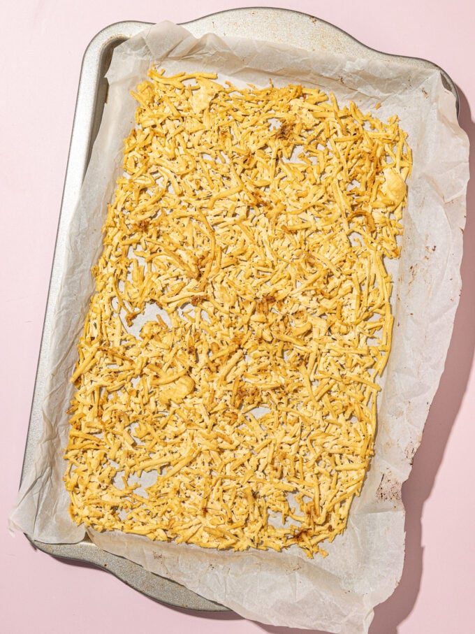 parchment lined baking sheet covered in baked shredded tofu