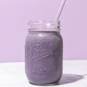 blueberry chickpea smoothie in mason jar with lavender coloured straw